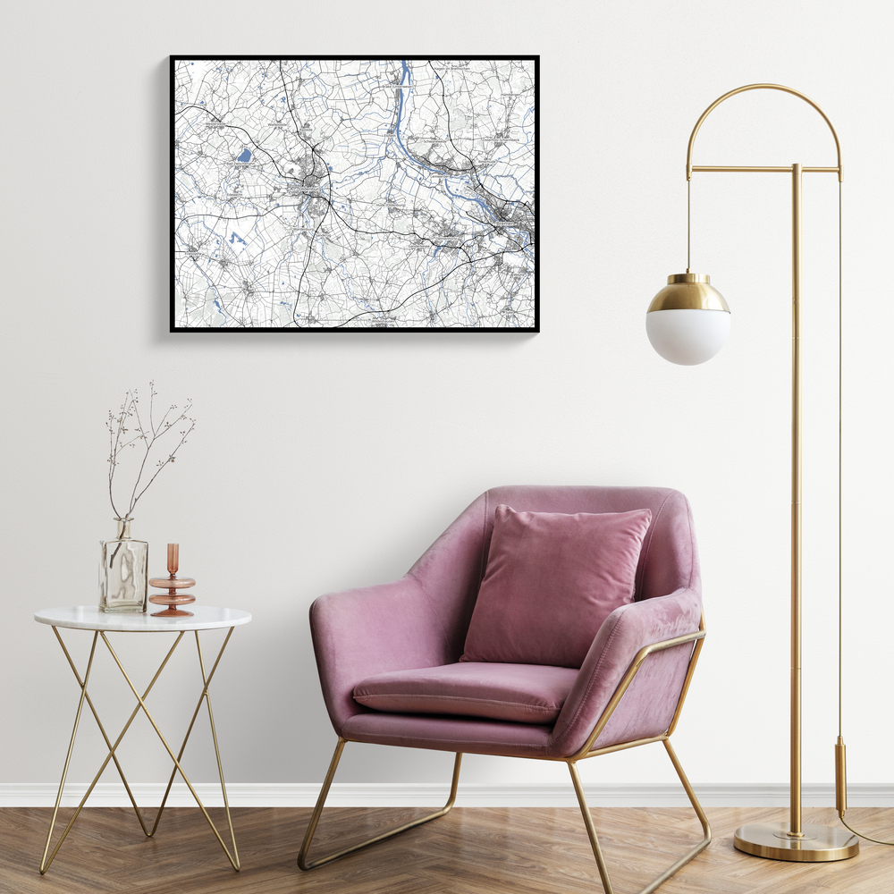 Mappa personalizzata con cornice nera sopra una poltrona rosa, accanto a una lampada da terra dorata