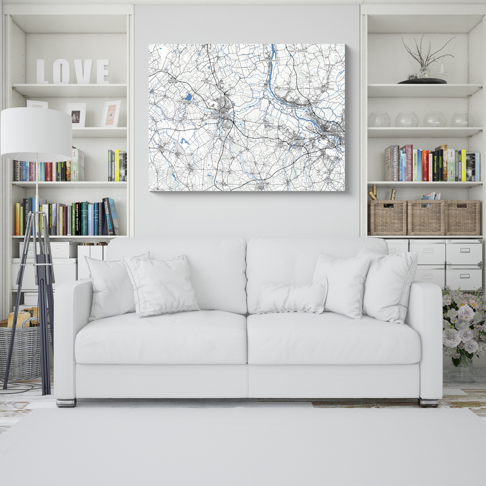 Mappa senza bordi con strade grigie e fiumi blu sopra un divano bianco, tra due librerie in soggiorno