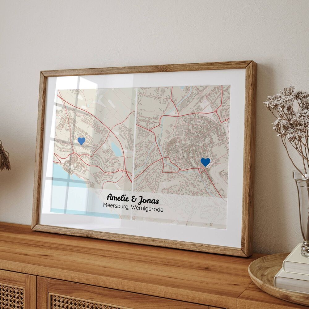 Stampa personalizzata con due mappe e cuori blu, in cornice di legno naturale su una credenza