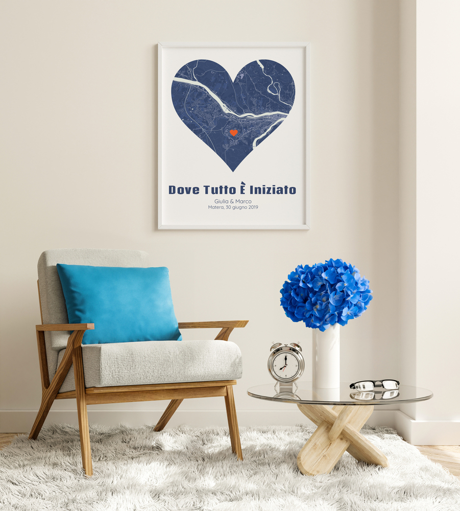 Mappa a cuore blu in cornice bianca sopra una poltrona, un regalo personalizzato per la coppia