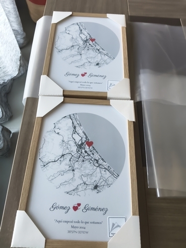 Due poster con mappe circolari e cuori, in cornici di legno naturale su un tavolo, come regalo romantico